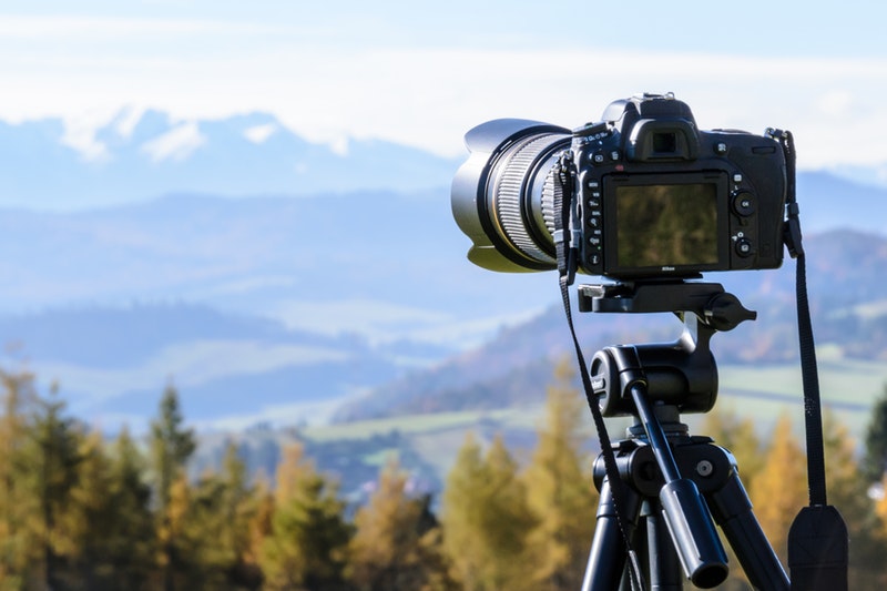 camera with telephoto lens on tripod