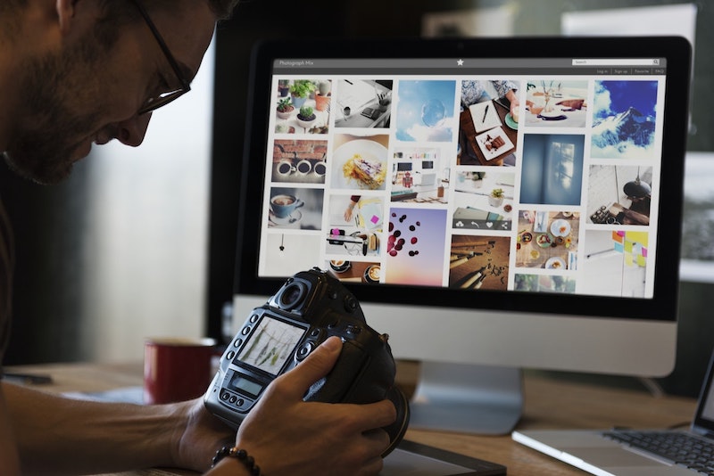 photographer at desk with camera and photoshop