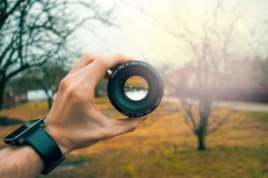 man holding camera lens